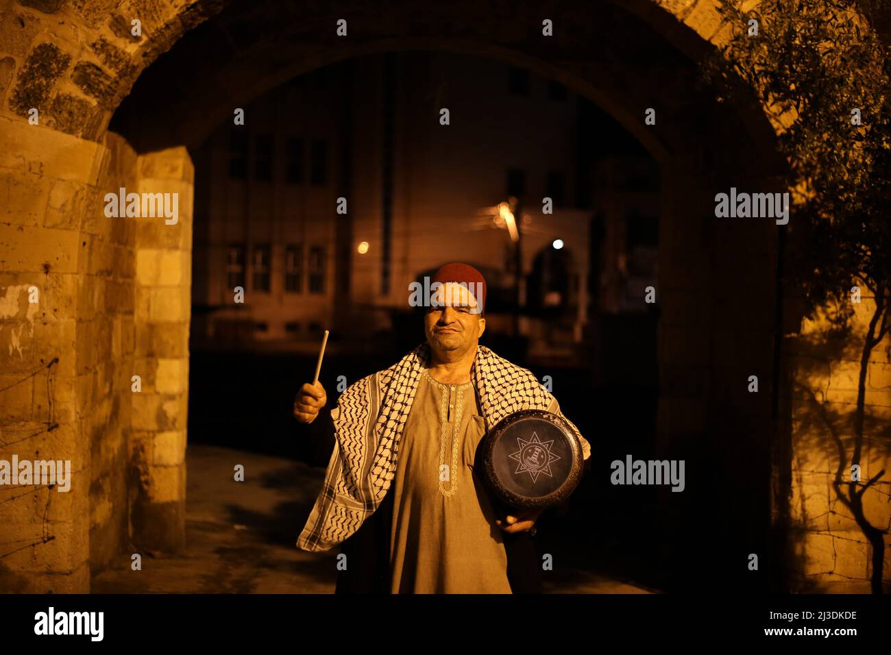 50-year-old Palestinian drummer 'Al-Masharati', Nizar Al-Dabbas, plays the drum to wake Muslims up for Suhoor (before dawn) during the first day of the holy month of Ramadan in Khan Yunis, Gaza. Stock Photo
