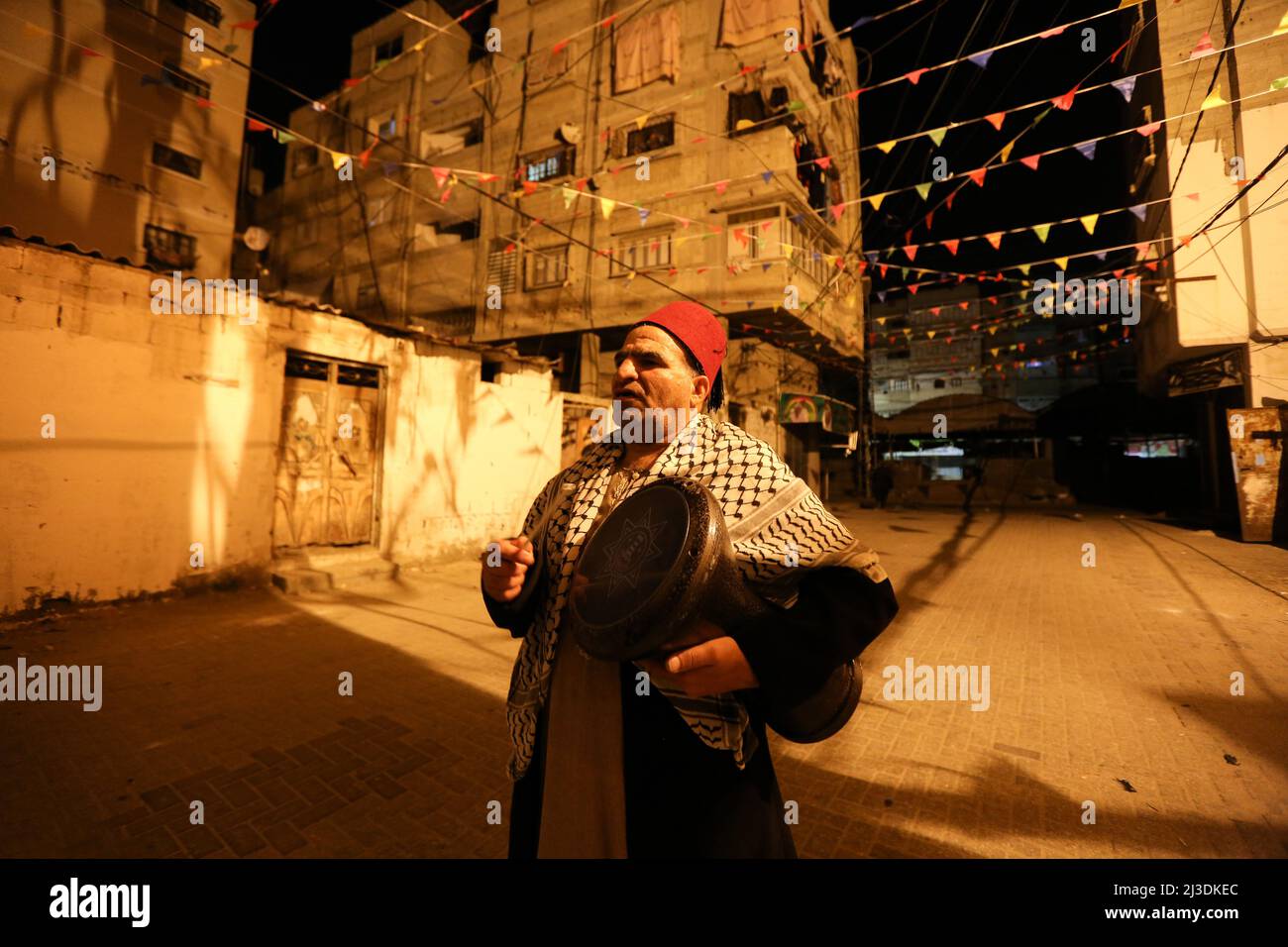 50-year-old Palestinian drummer 'Al-Masharati', Nizar Al-Dabbas, plays the drum to wake Muslims up for Suhoor (before dawn) during the first day of the holy month of Ramadan in Khan Yunis, Gaza. Stock Photo