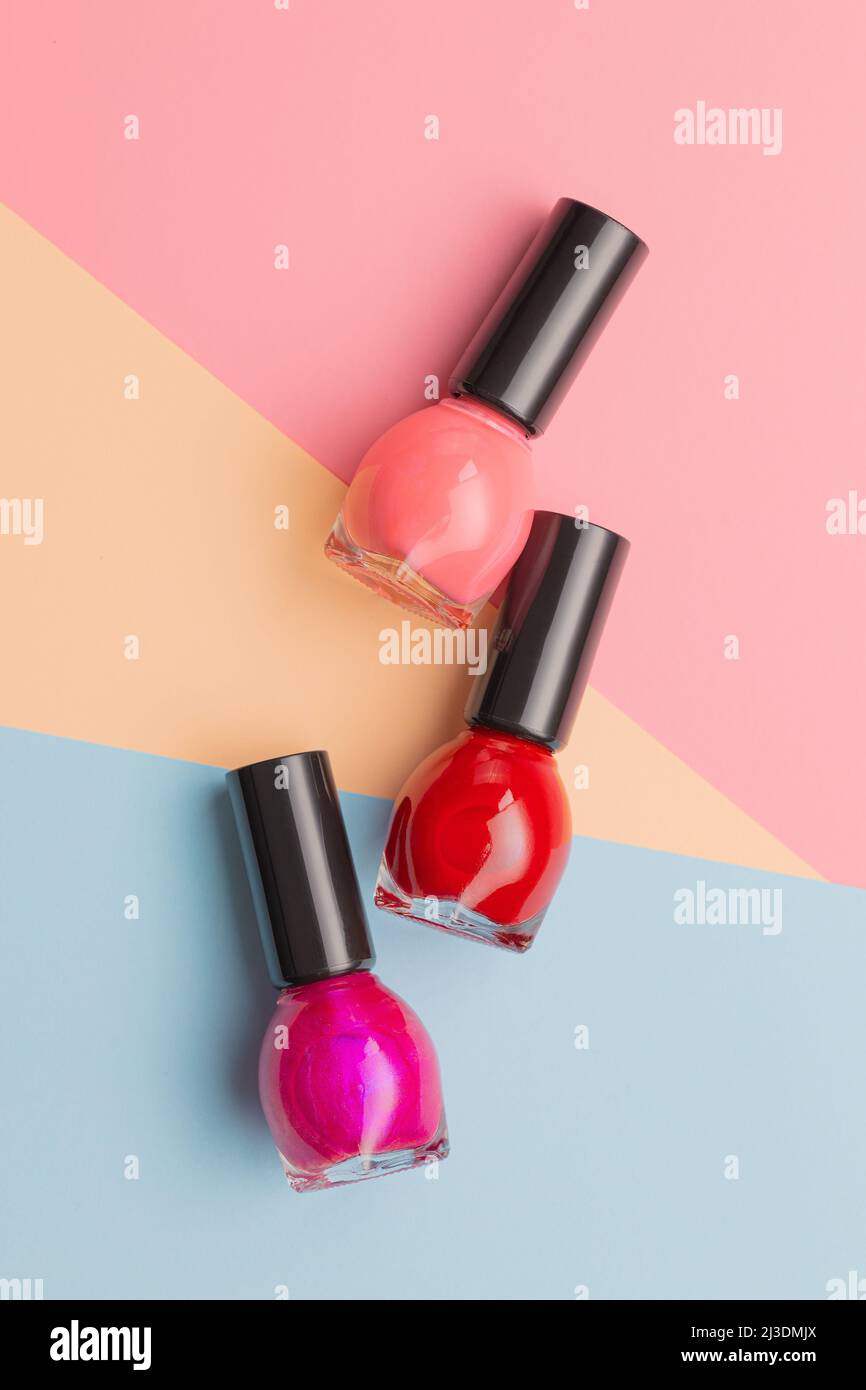 Colorful nail polish bottles on a colorful background. Top view. Stock Photo