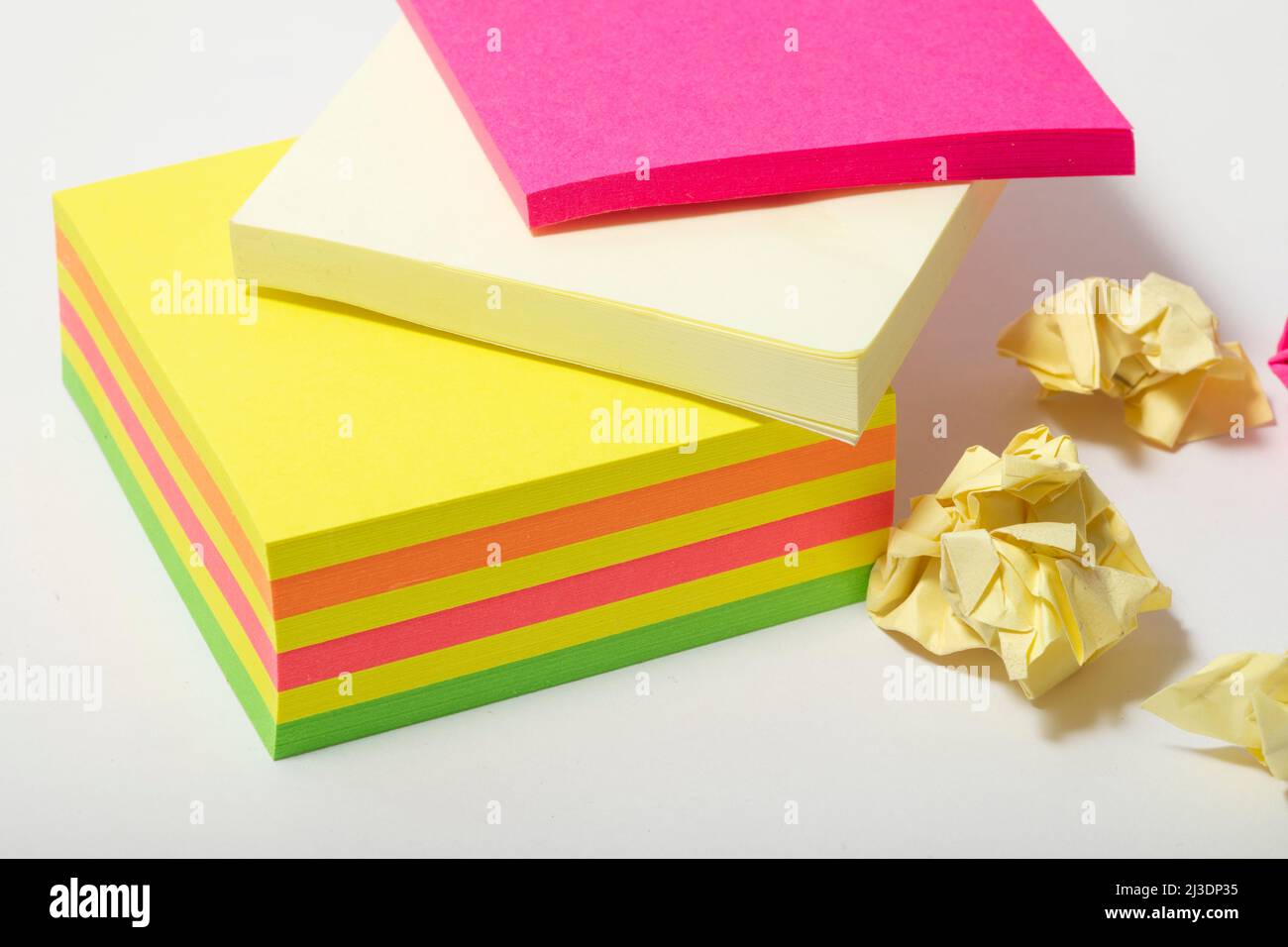 close up of multi-coloured stack of post it notes some screwed up and left to one side no people nobody copy space Stock Photo