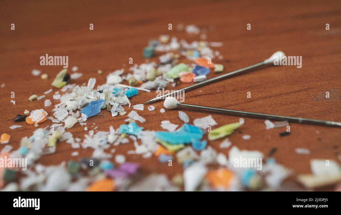 Close up side shot of microplastics with pins for size comparison.. Concept for water pollution and global warming. Stock Photo