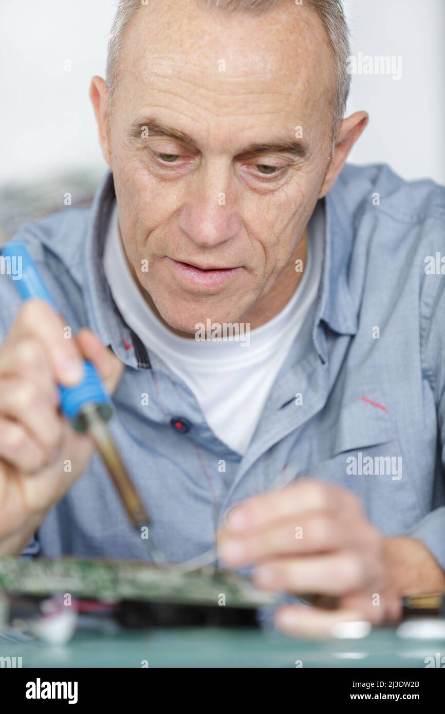 a mature worker soldering pc parts Stock Photo Alamy