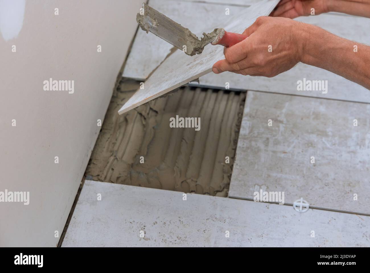 Man installs placing the ceramic tile over floor Stock Photo Alamy
