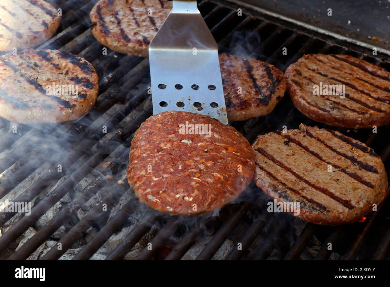 beef meat burger patty on a hot smoky barbeque grill Stock Photo - Alamy