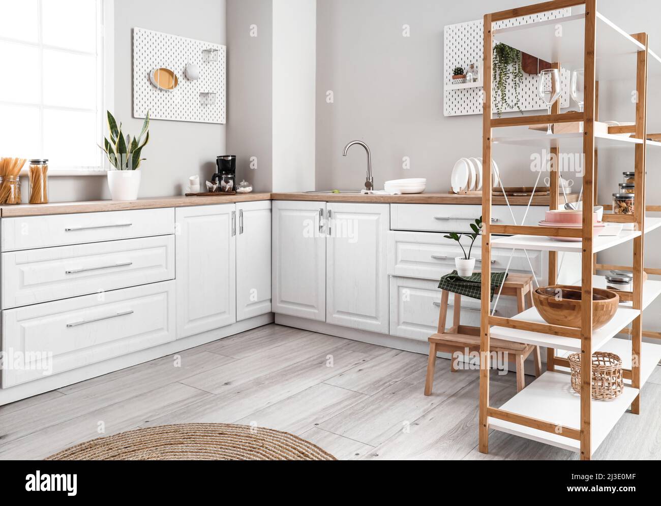 Interior of modern kitchen with counters and shelving unit Stock Photo