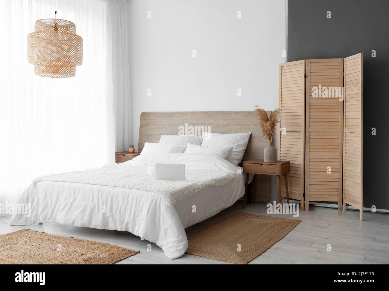 Interior of stylish bedroom with folding screen and wicker rugs Stock ...