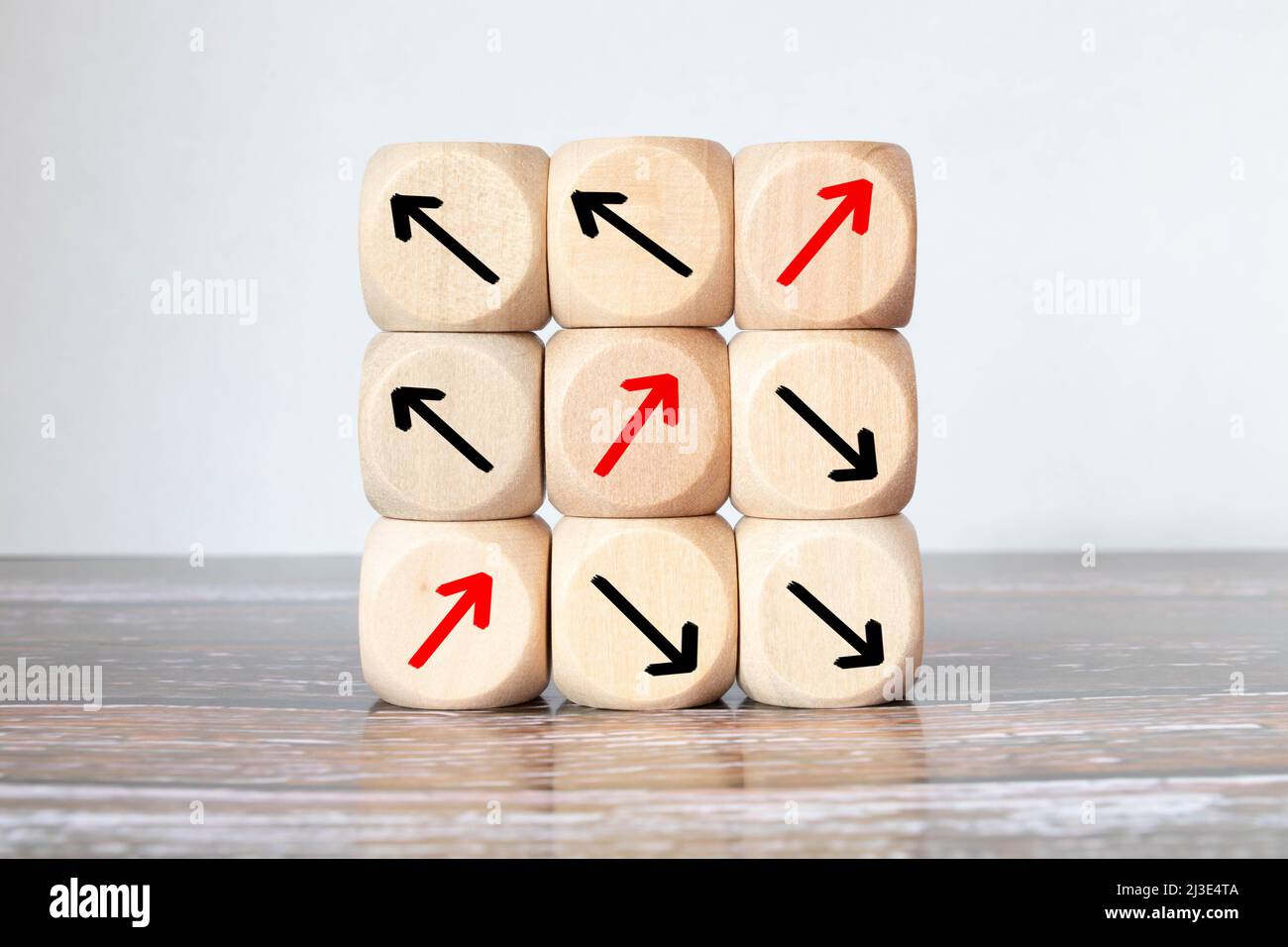 Wooden cube with an arrow symbol pointing in a different direction from ...