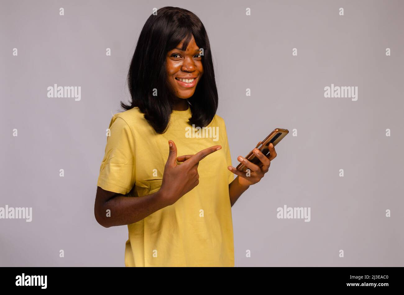 beautiful young black woman using her phone looking happy Stock Photo ...