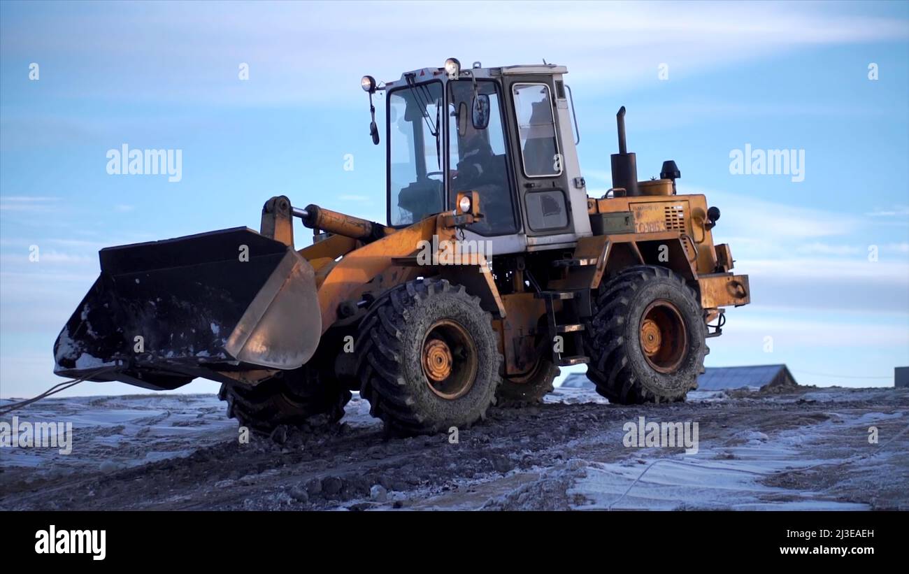 Snowy weather, excavator digging frozen ground. Clip. Heavy industry