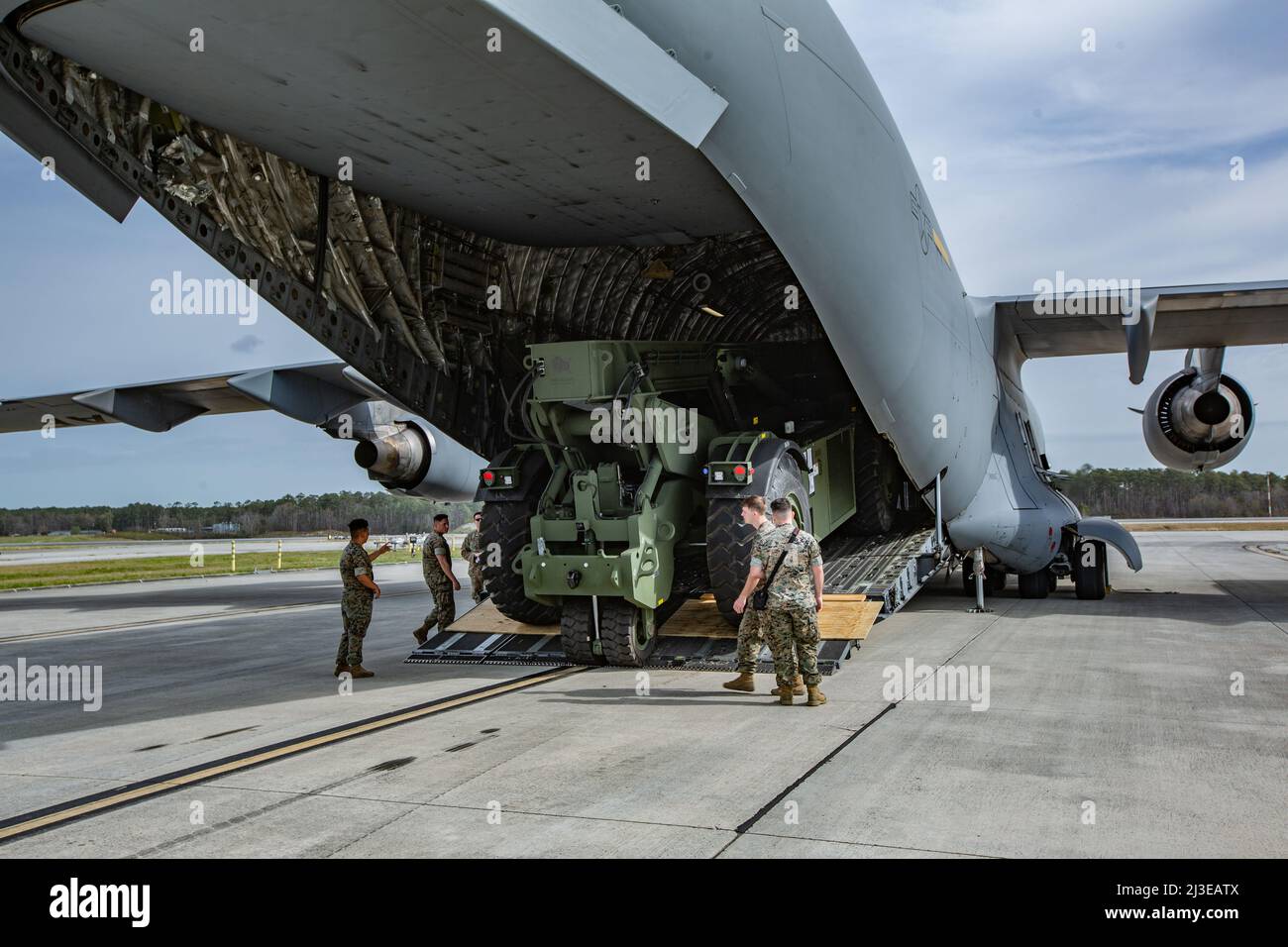 U.S. Marines and U.S. Airmen load a Kalmar RT240 on a C-17 Globemaster ...