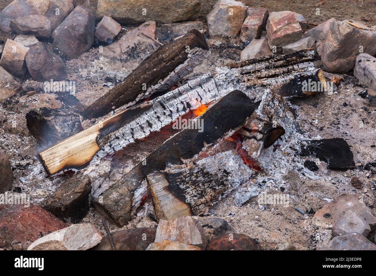 Campfire encircled with rocks on sandy beach Stock Photo - Alamy