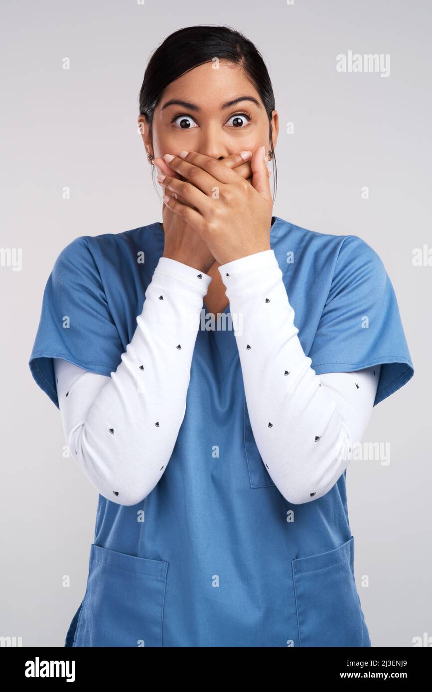 A celestial sphere, were weightless as the waves that disappear. Portrait of a shocked young doctor in scrubs against a white background. Stock Photo