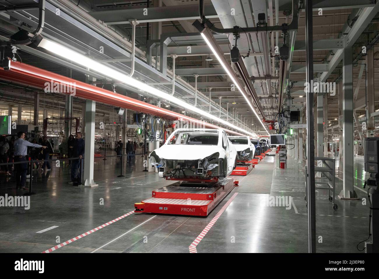 Austin Texas USA, April 7 2022: Machinery on automated production line  holds partially built cars at the new Tesla Gigafactory Texas as guests  tour the facility during its private grand opening event.