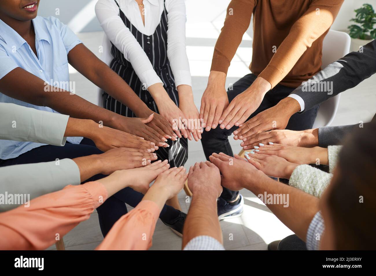 Team of happy multiethnic men and women together putting their hands in a circle Stock Photo