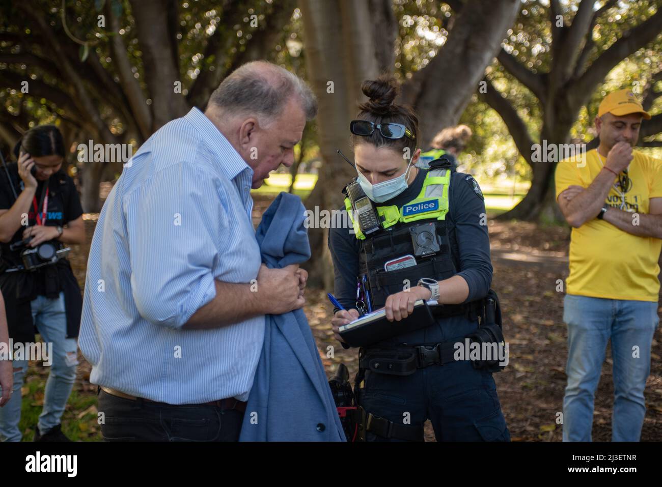 8th April 2022, Melbourne, Australia. MP and member of United Australia Party Craig Kelly talks to police after being egged by a heckler, holding his jacket with egg yolk. Credit: Jay Kogler/Alamy Live News Stock Photo