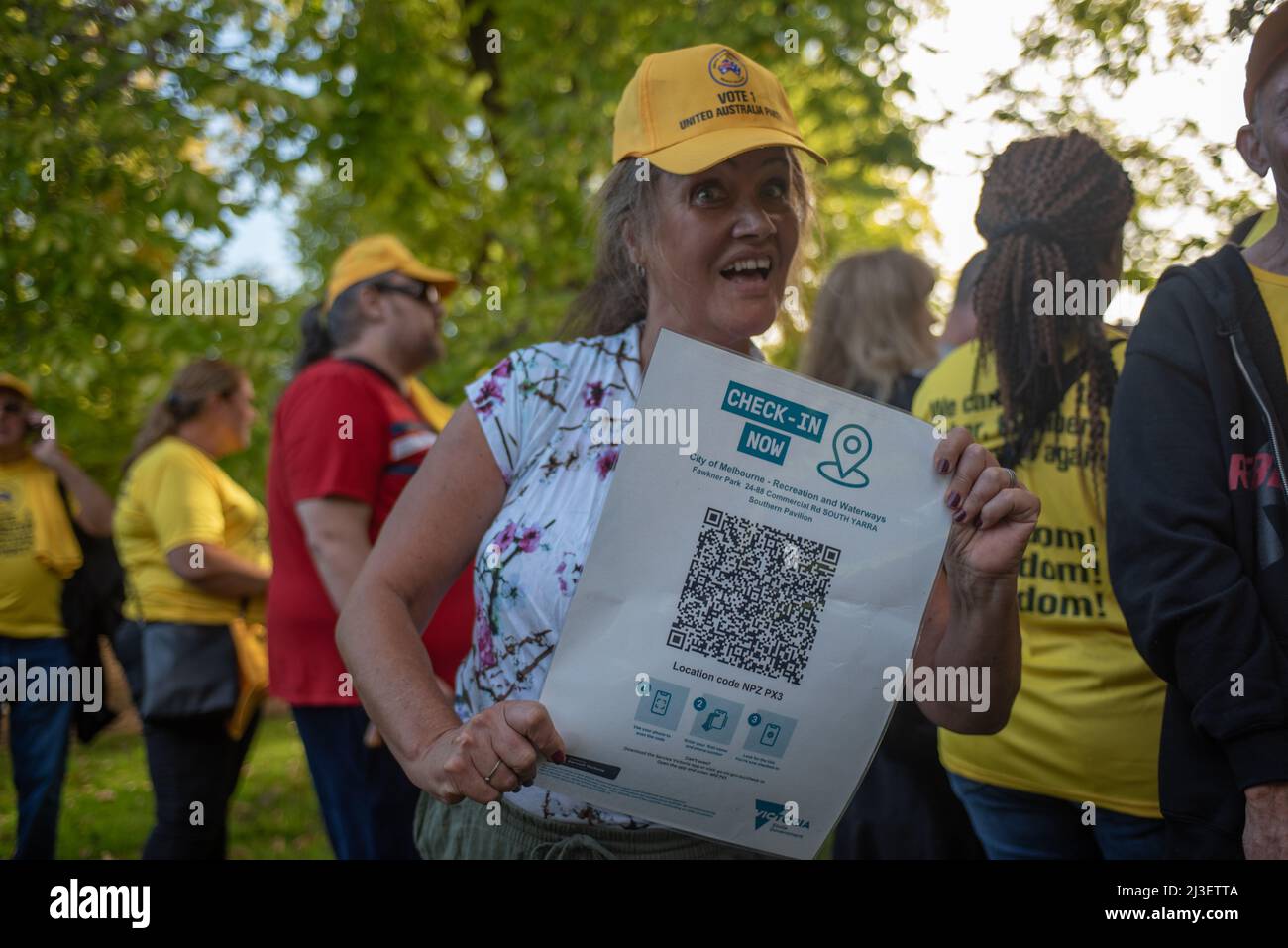 8th April 2022, Melbourne, Australia. An attendee of a United Australia Party barbecue rally in Fawkner Park holds a mock QR check-in sign. Credit: Jay Kogler/Alamy Live News Stock Photo