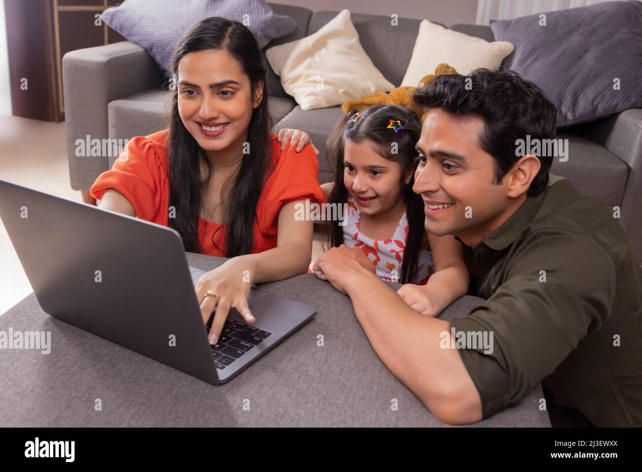 Parent using laptop with their girl child at home Stock Photo Alamy