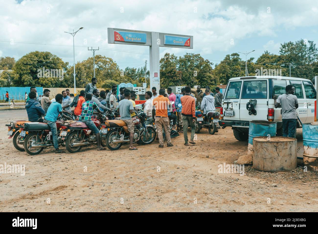 Jinka, Southern Nations Ethiopia - May 16, 2019: Young Ethiopian men, bikers, waiting at a gas station for refueling. City Jinka, Southern Nations Eth Stock Photo