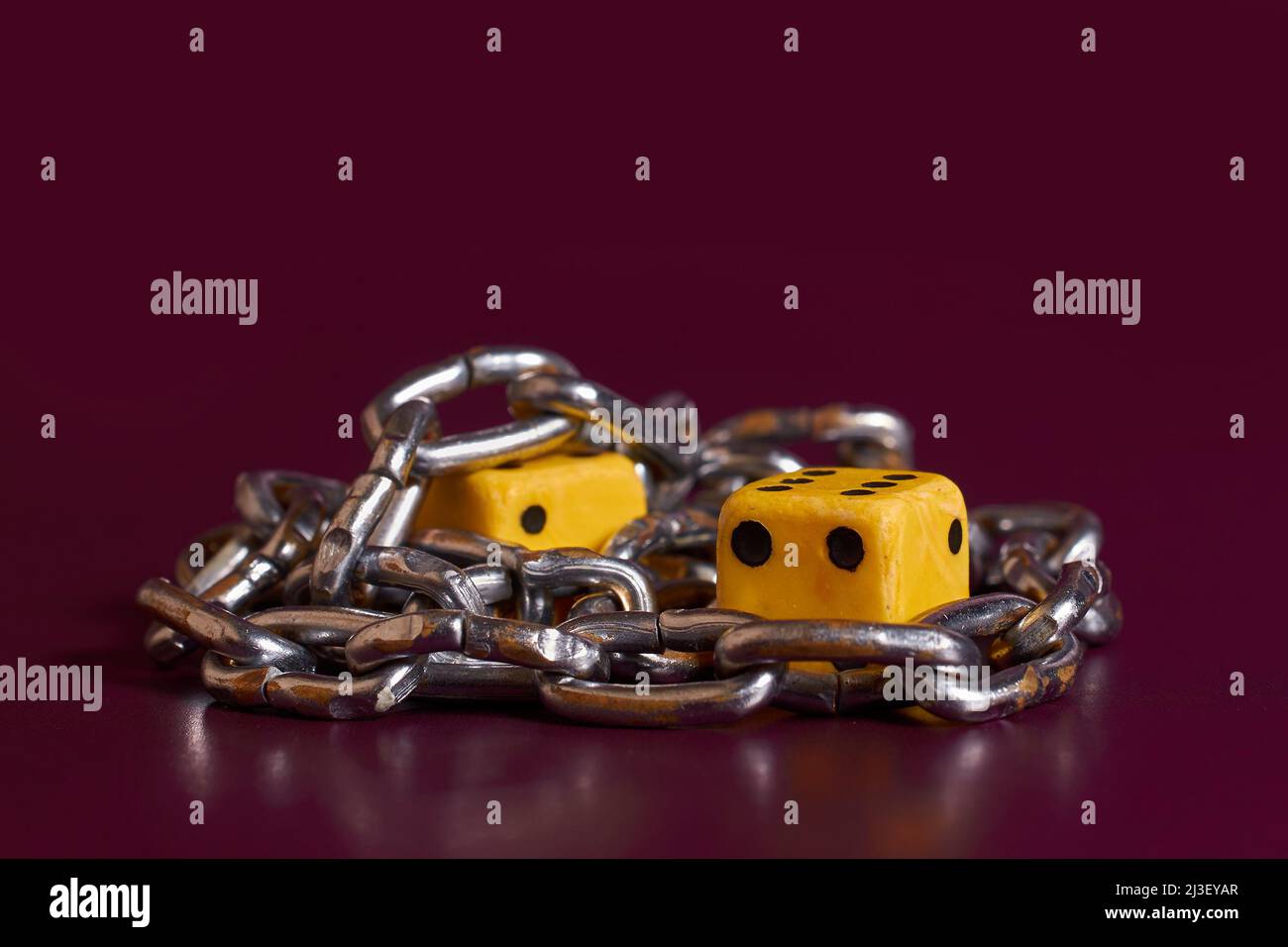 Gambling addiction. Two dice is wrapped with a chain  Stock Photo