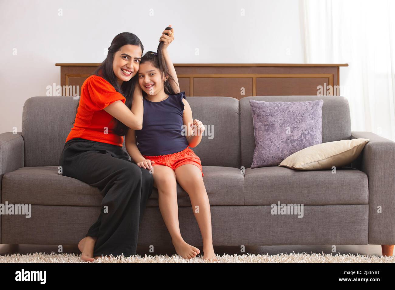 Mother having fun with her daughter by pulling hair Stock Photo
