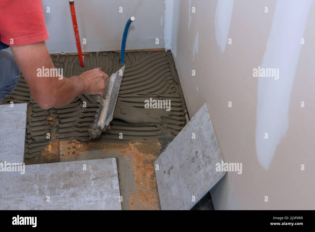 Process laying floor ceramic tiles, application of the adhesive base Stock Photo Alamy