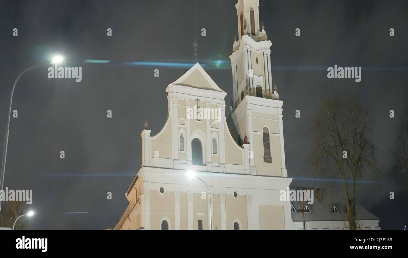Old Catholic Church in night city. Action. Beautiful light temple illuminated at night. Catholic