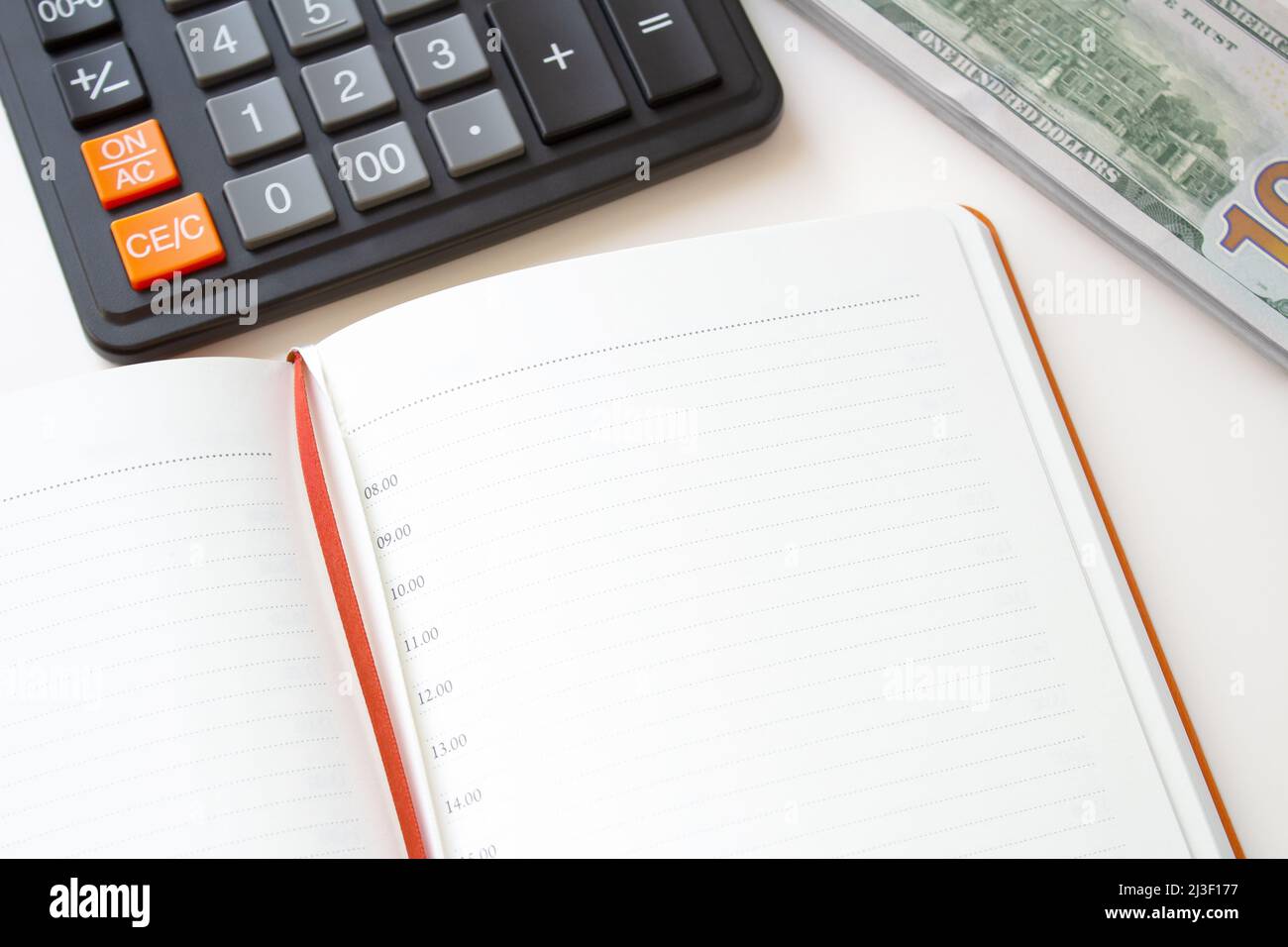 Calculator notepad and stack of money on white background. Stock Photo