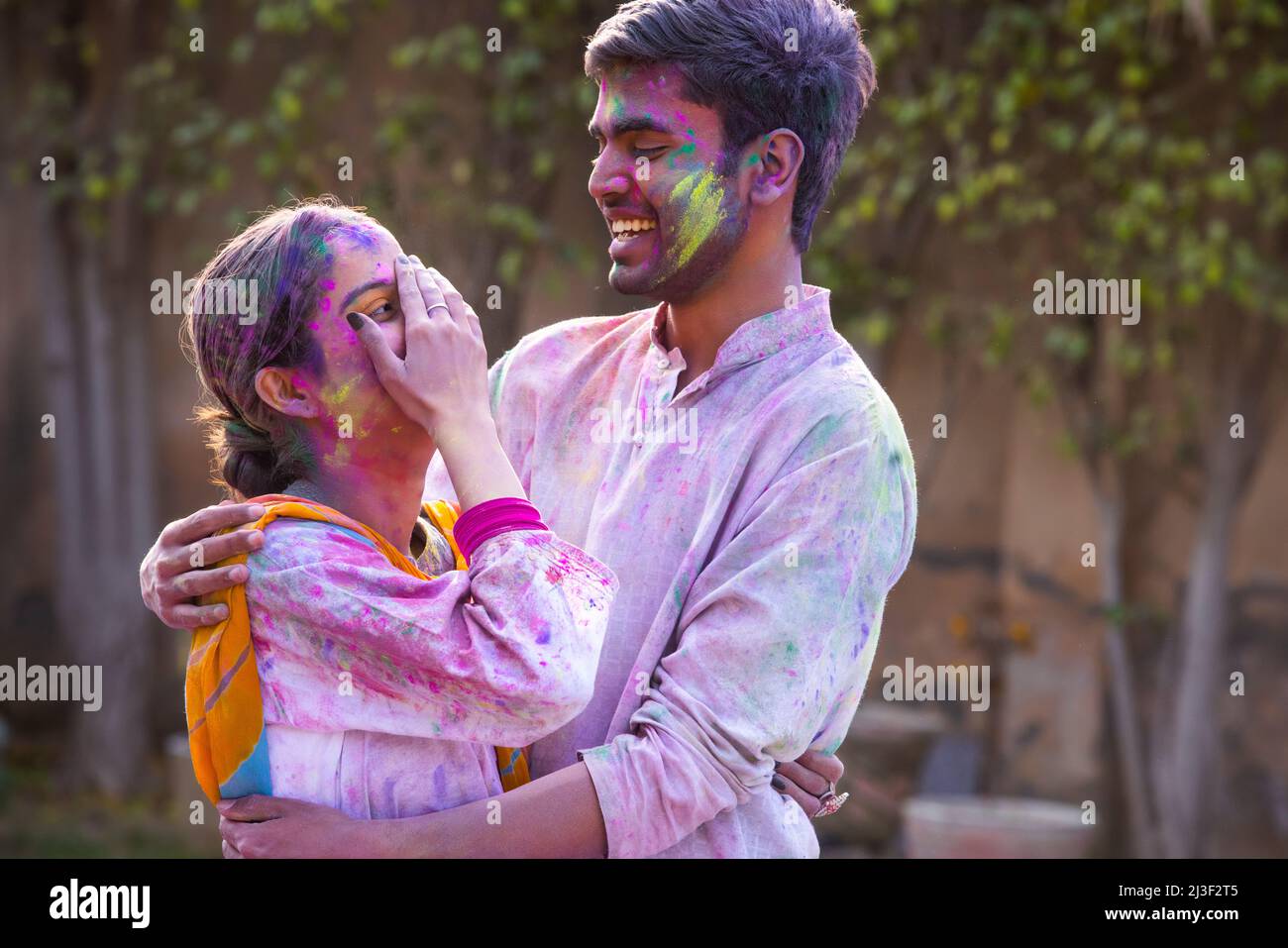Portrait romantic young couple celebrating Holi Stock Photo