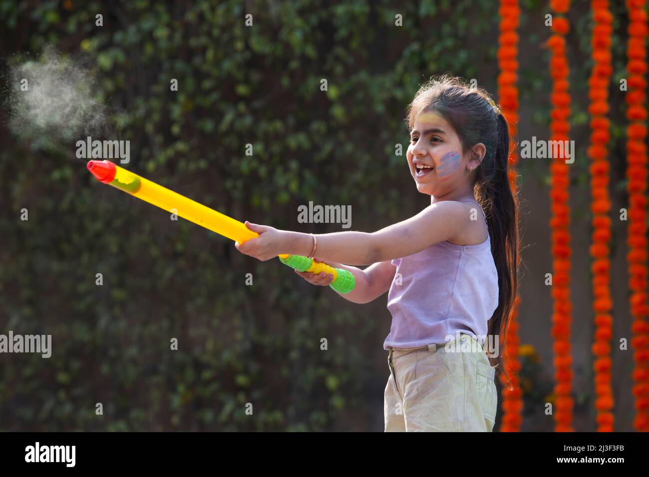 child filling pichkari for holi