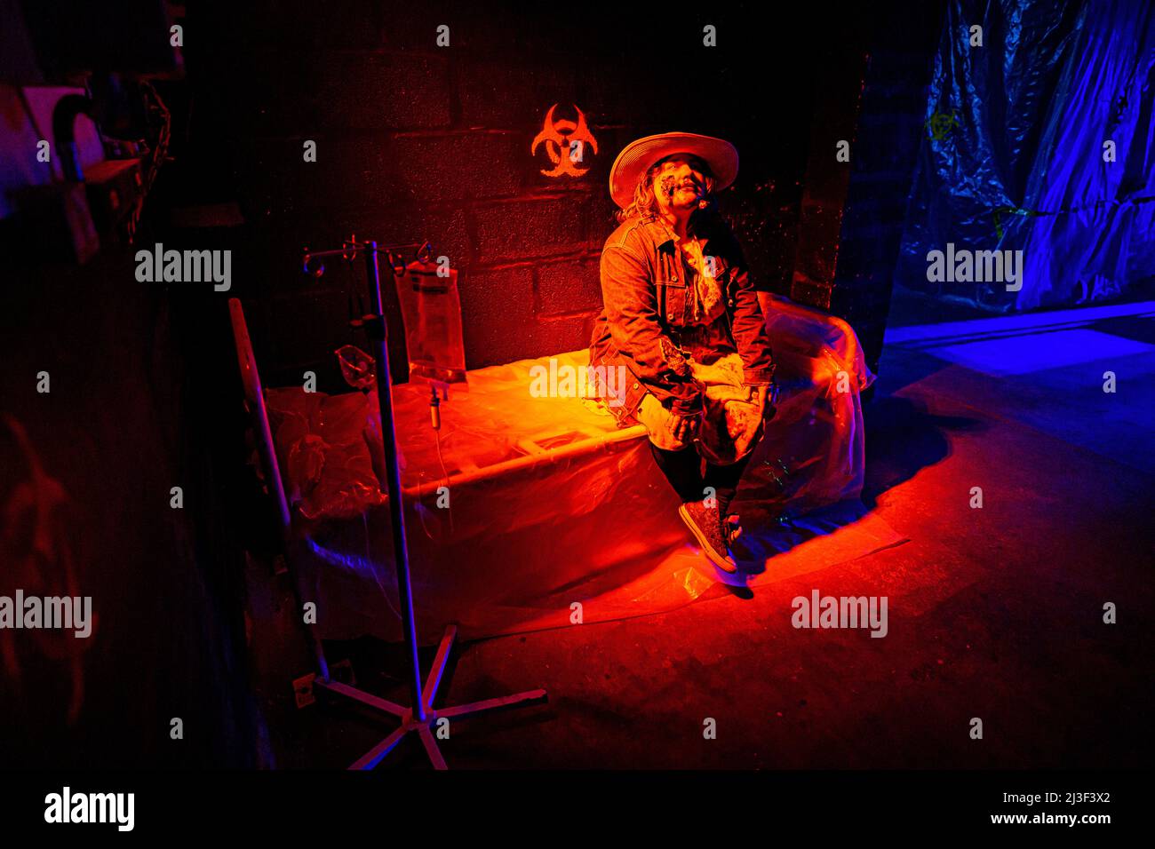 A zombie actor sits on a hospital bed in characters as they wait inside Shepton Mallet prison, where characters are preparing for an immersive terror event taking place into the weekend with zombies and real-life scary characters in the old prison workshop building. Picture date: Thursday April 7, 2022. Stock Photo