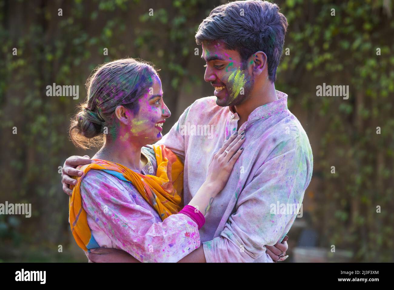 Portrait romantic young couple celebrating Holi Stock Photo - Alamy