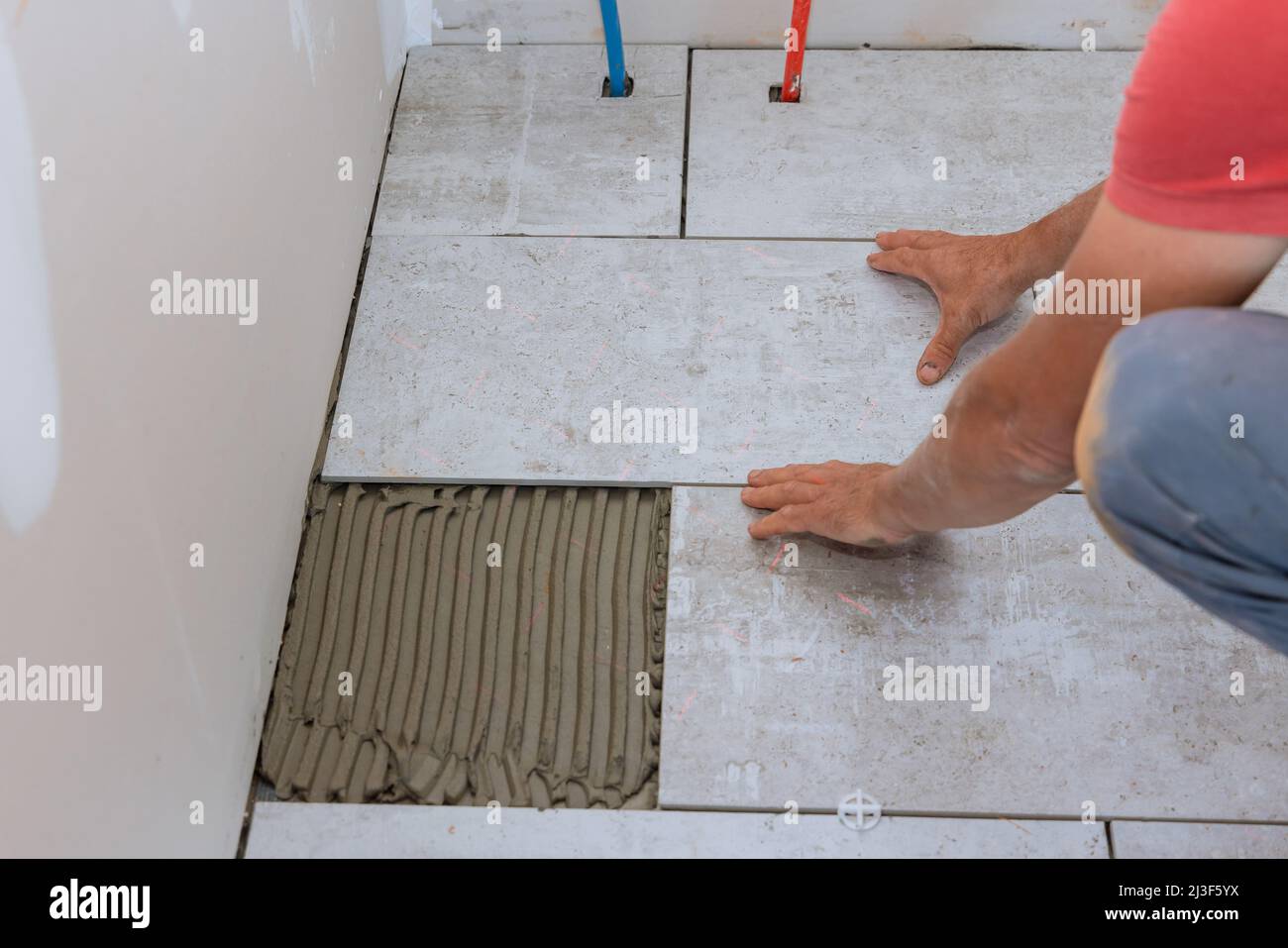 Floor ceramic tile installation with home construction working Stock