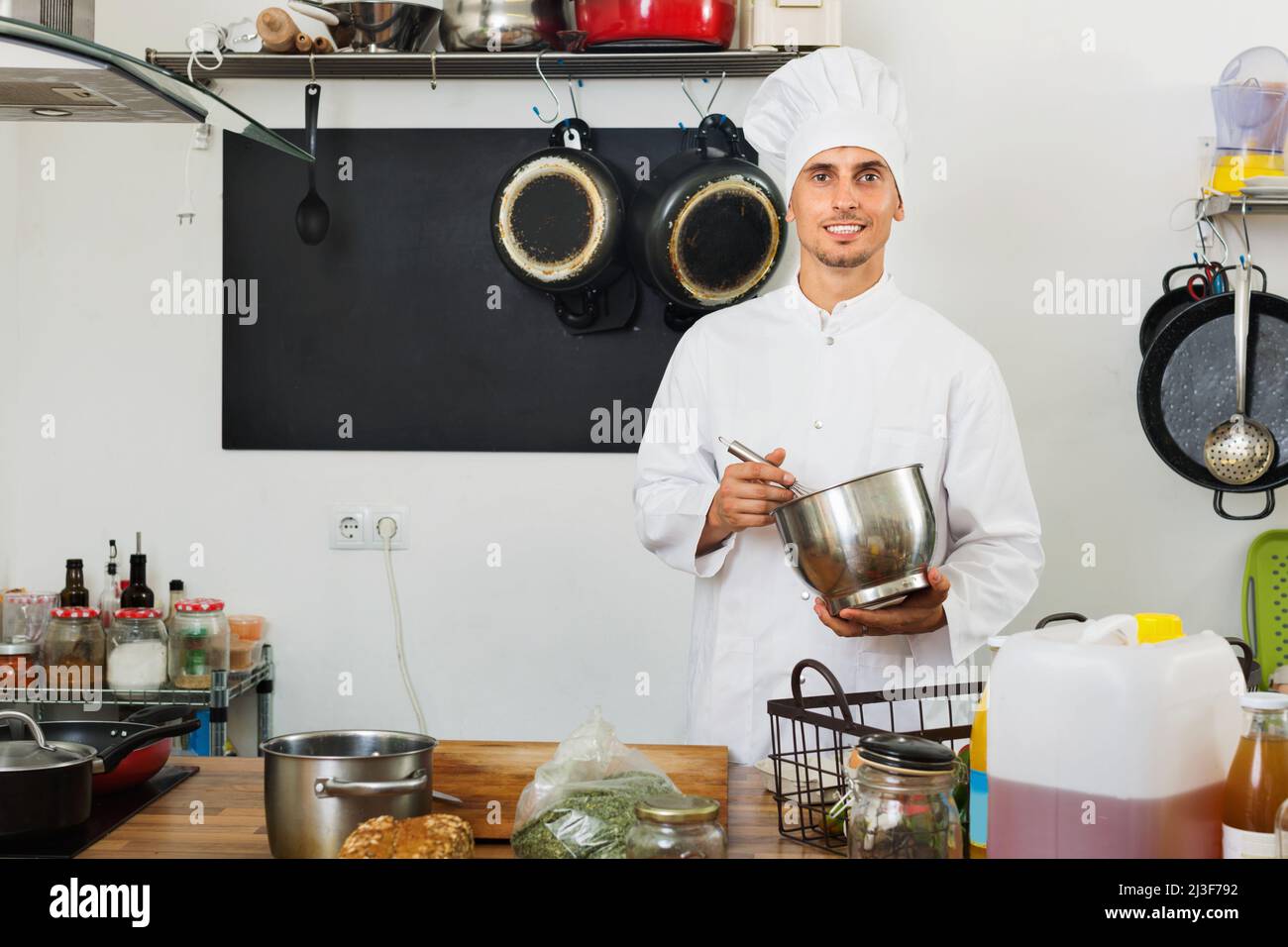 Male cook wearing uniform working on kitchen Stock Photo