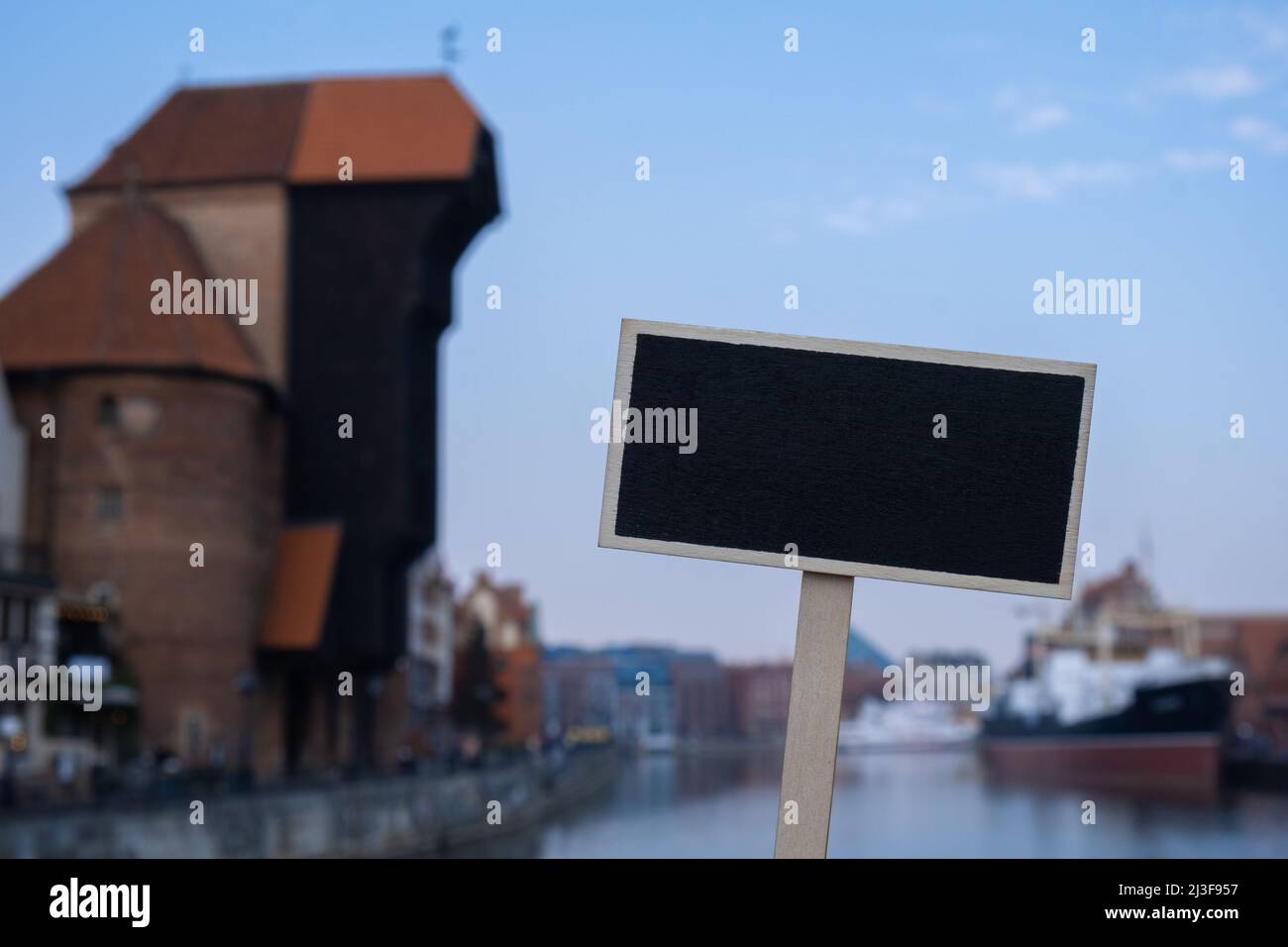 Empty mockup template Blackboard label against Gdansk beautiful old town over Motlawa river. The Zuraw Crane and colorful gothic facades of the old Stock Photo