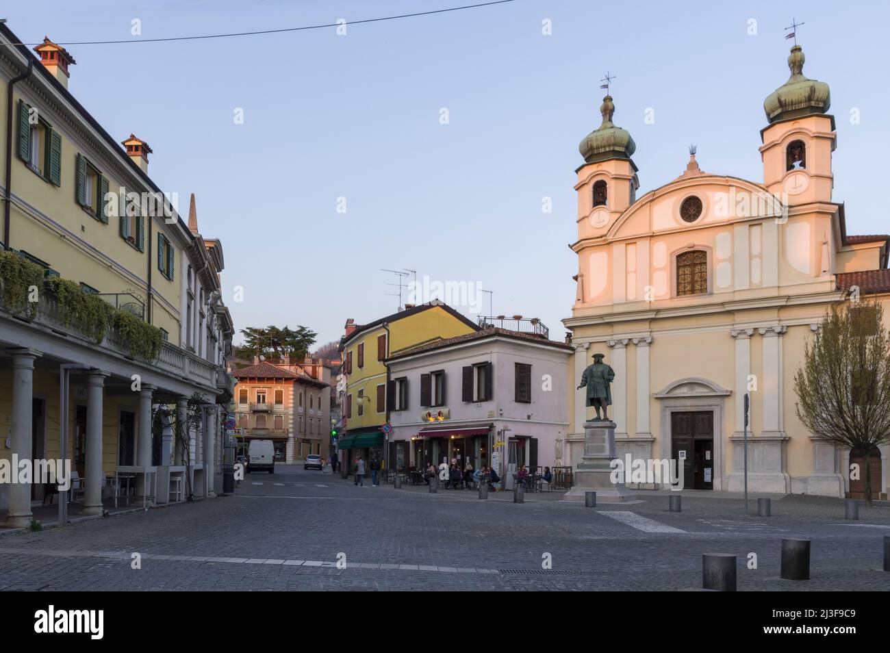 Cormons, Italy (27th March 2022) - The central Piazza Libertà square with the statue of Maximilian I of Habsburg and the church of Santa Caterina Stock Photo