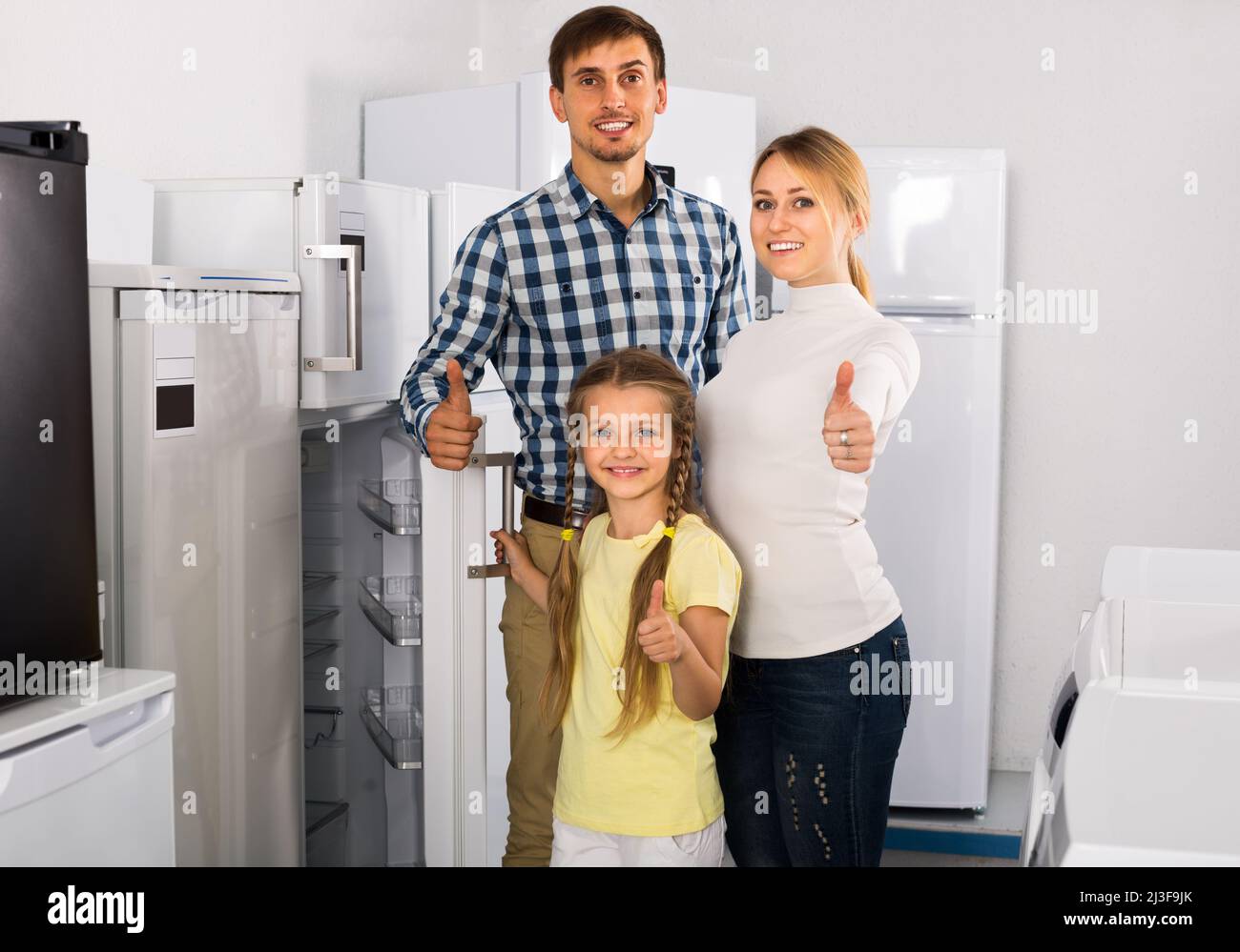 Family with child choosing refrigerator Stock Photo