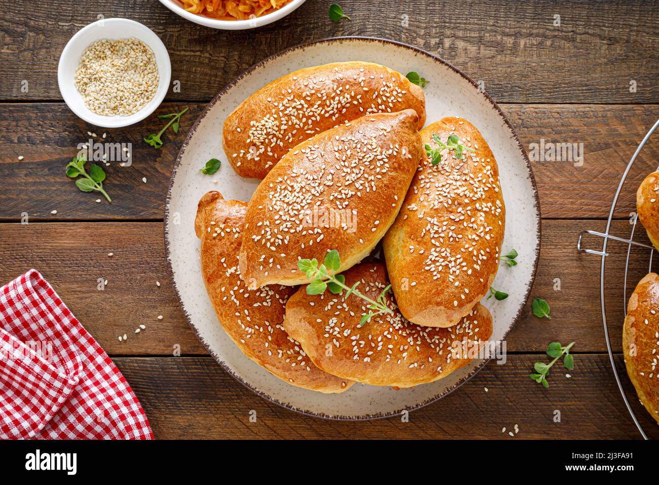 Homemade baked pies or patties stuffed with cabbage on wooden background. Top view Stock Photo