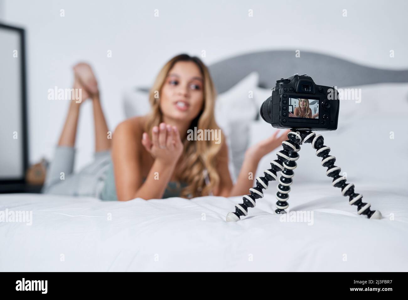 Today Im sharing a little bit more about myself. Shot of a young woman using a tripod while recording herself at home. Stock Photo