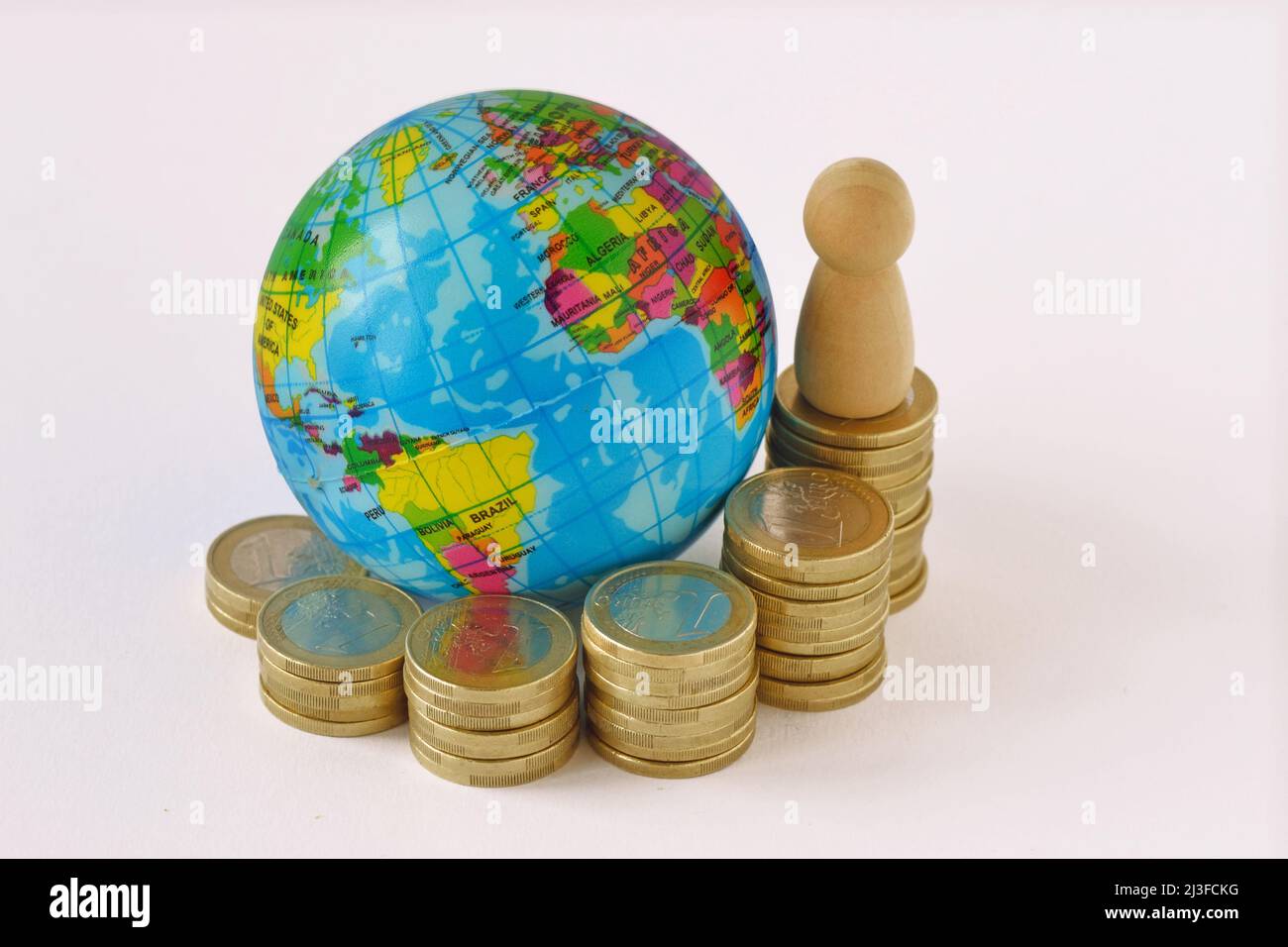 World planet and raising coins stack with pawn - Concept of global economy Stock Photo