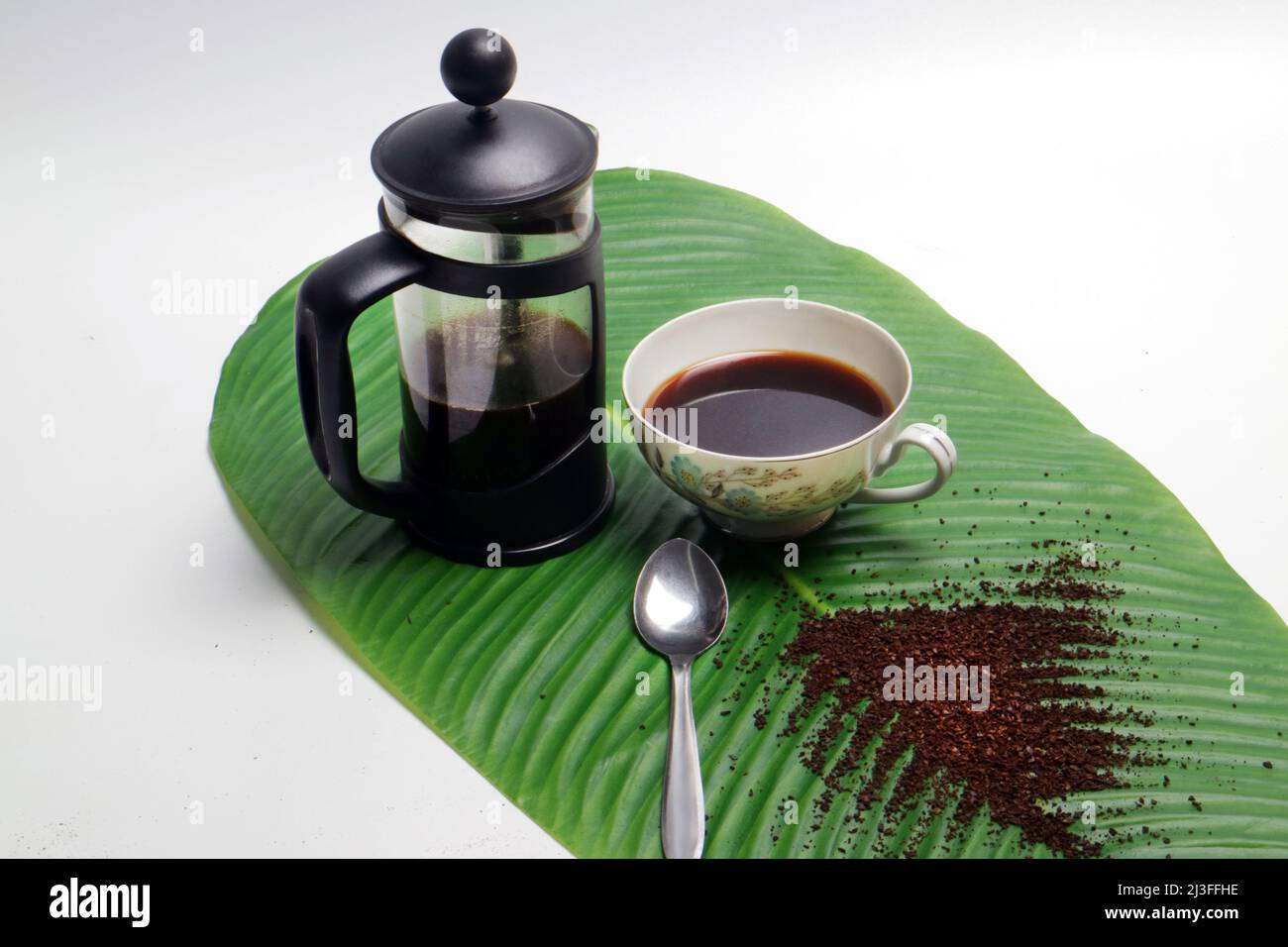 photo studio of french press coffee with cup of coffee spoon and coarse