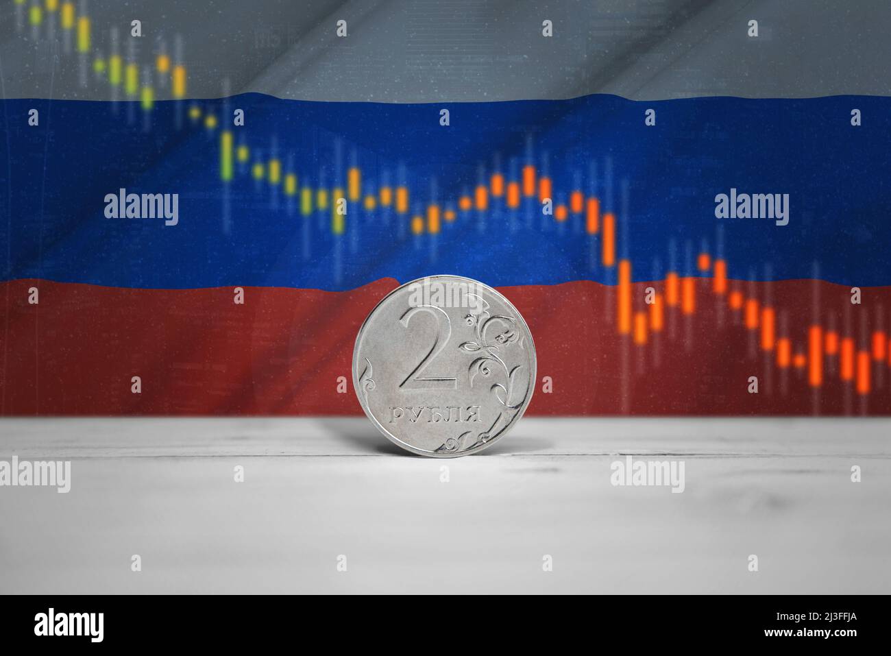 Ruble coin on table. Chart of the fall and celebration of the Russian currency on the Russian flag in background Stock Photo