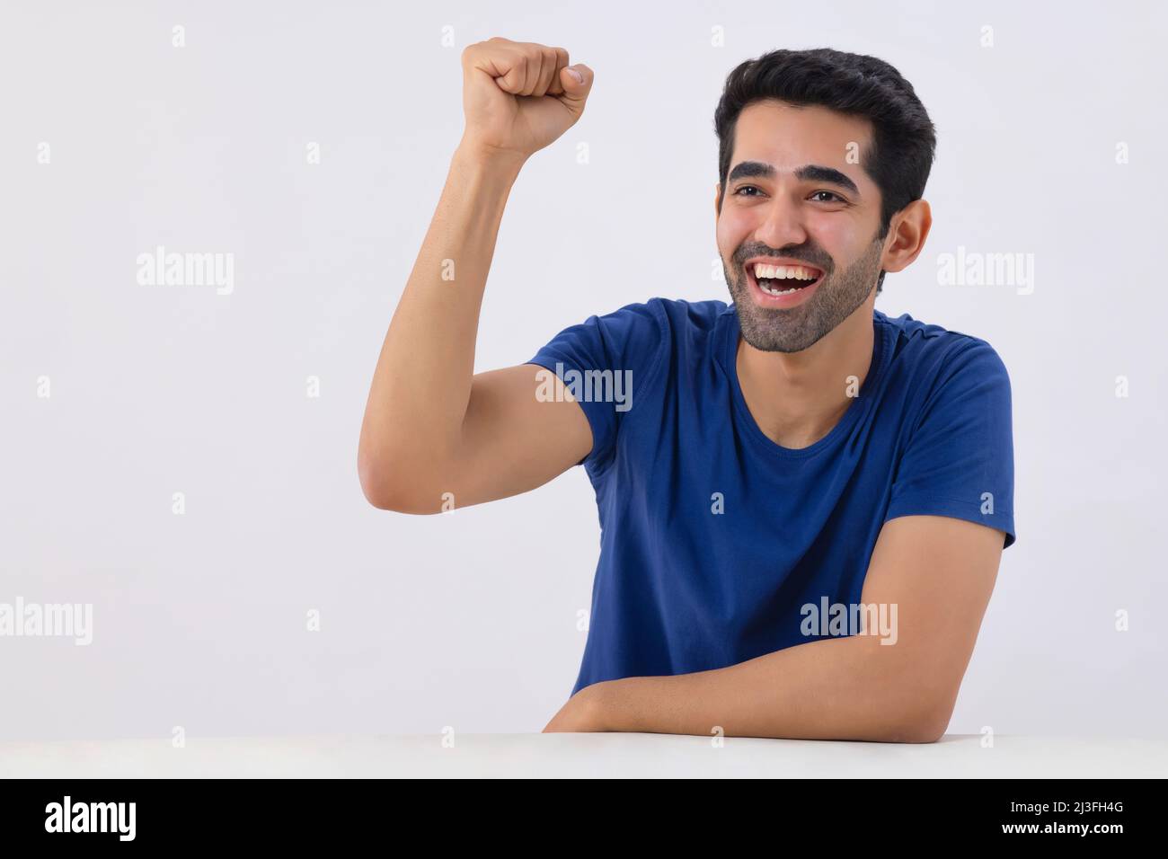 Portrait of a young man celebrating victory by raising his fist Stock Photo