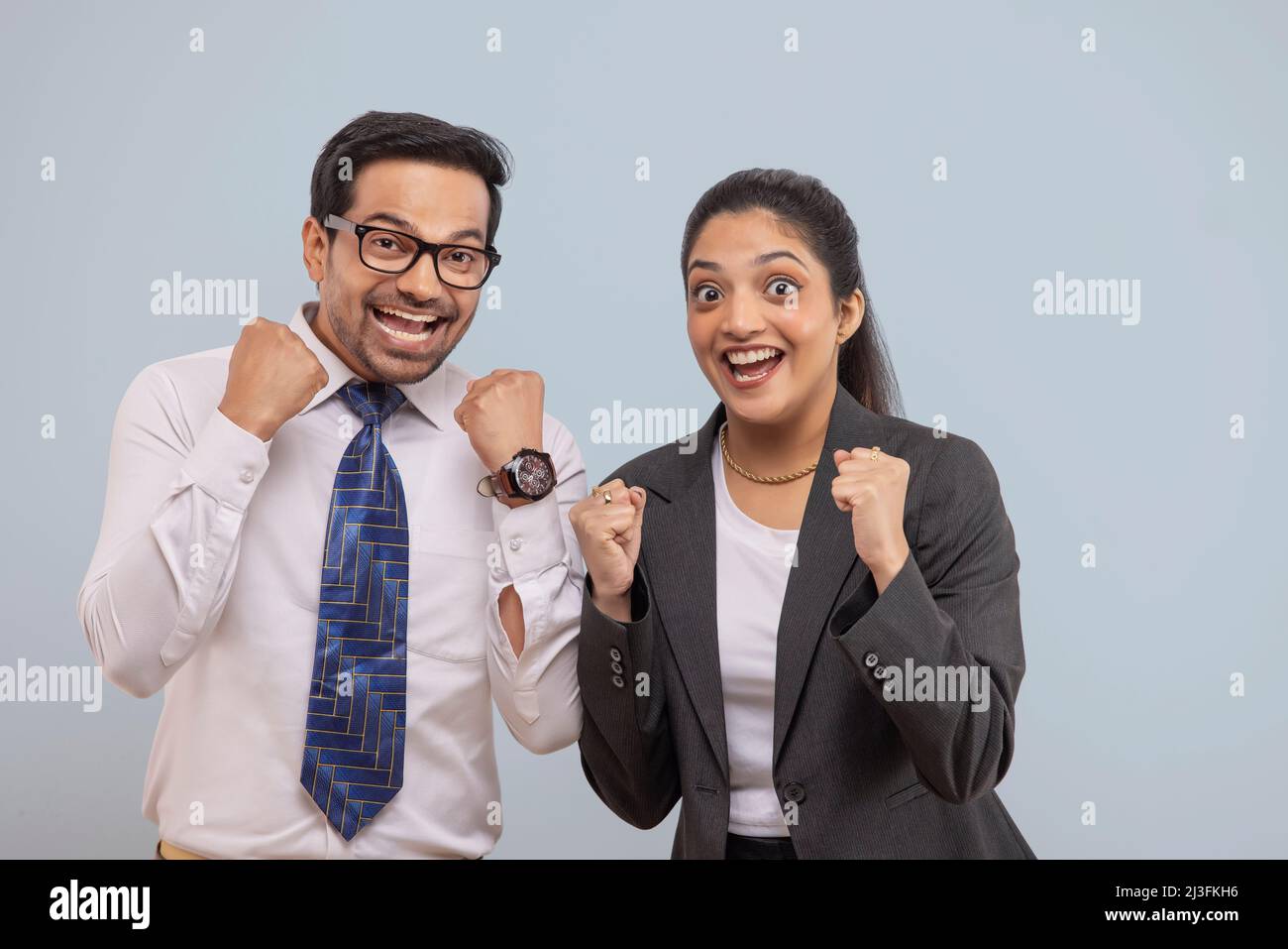 Happy corporate couple cheering with raising their fists Stock Photo