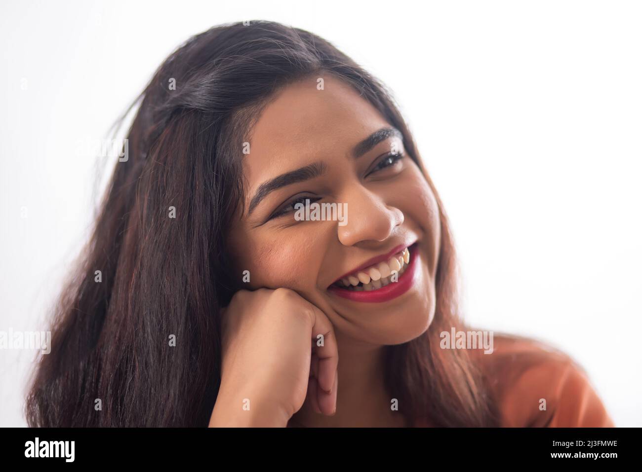 Close-up portrait of smiling woman with hand on cheek Stock Photo