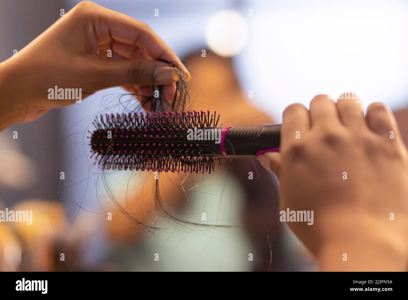 Close-up of woman holding a comb with lost hair Stock Photo