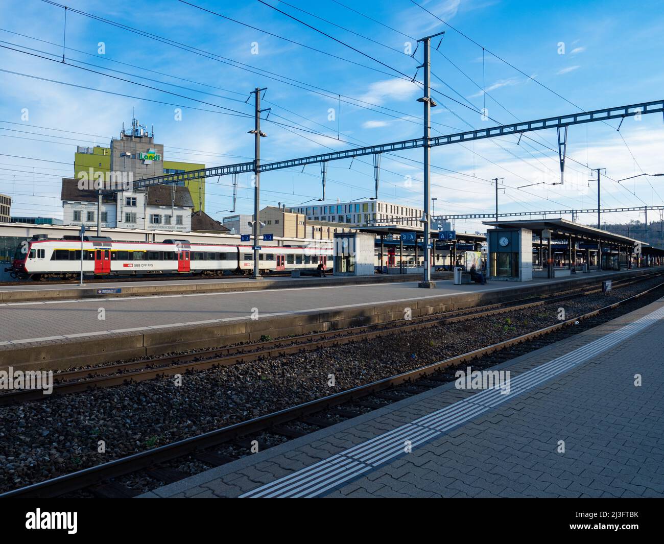 Brugg AG, Switzerland - March 13th 2022: Railway station surrounded by modern and industrial buildings Stock Photo
