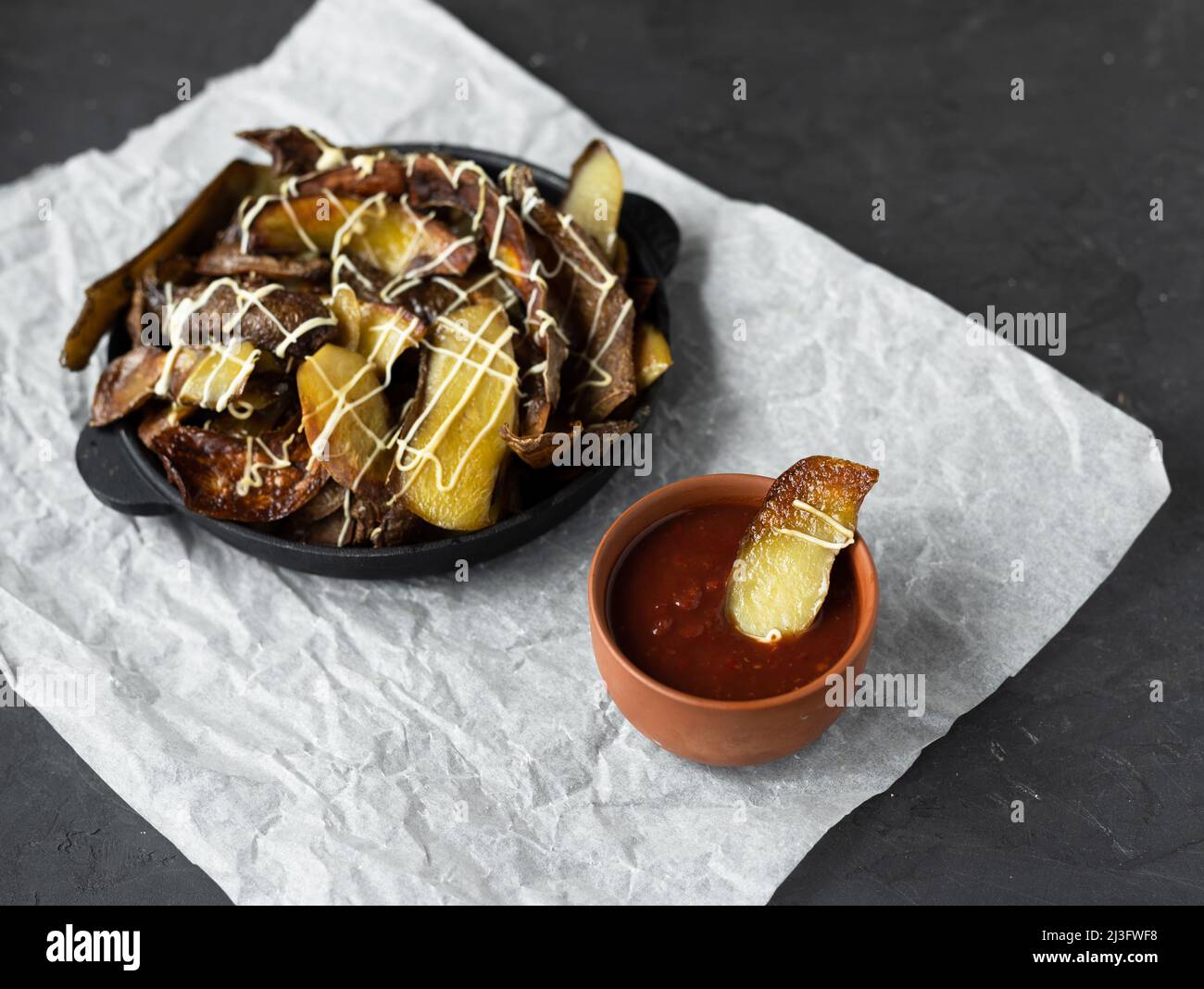 Potato nachos in a cast iron skillet. Crispy baked potato skins are