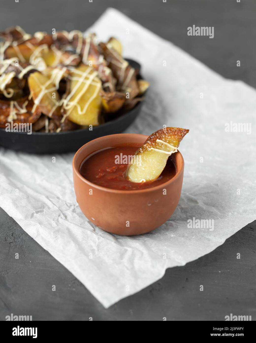 Potato nachos in a cast iron skillet. Crispy baked potato skins are
