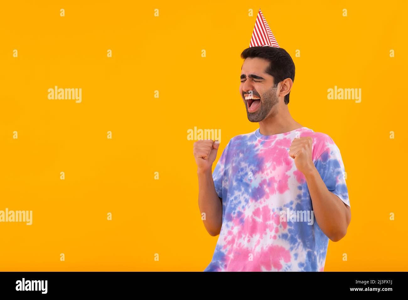 Portrait of excited young man cheering with raising fists Stock Photo