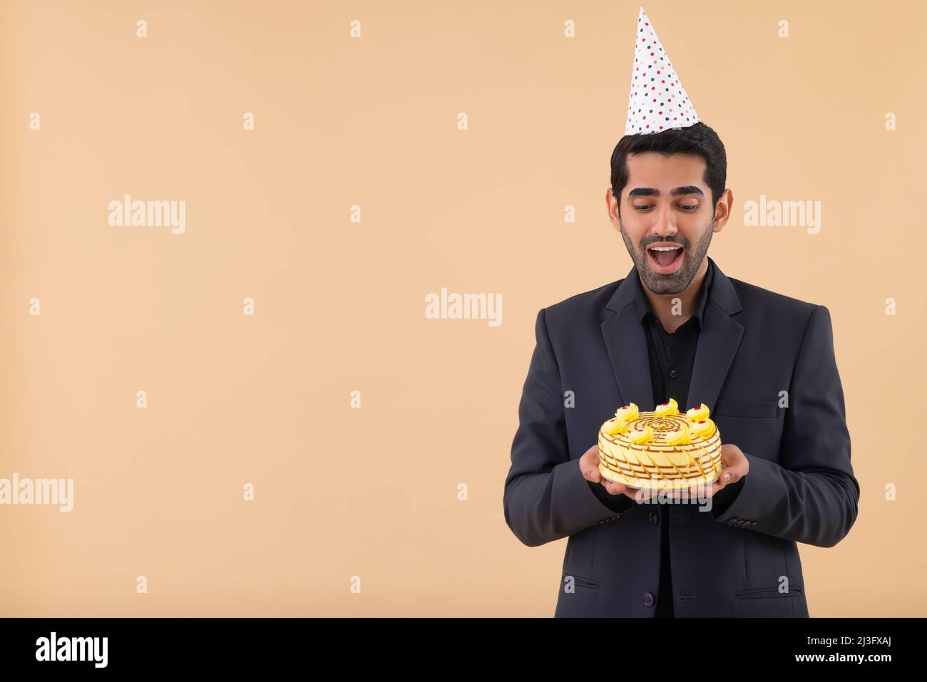 Portrait of a happy businessman wearing a party hat with a birthday